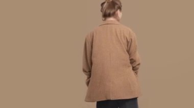 Sarışın mankenin moda portresi stüdyoda renkli arka planda parlak bir kapak takıyor.