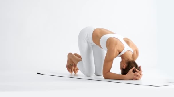 Senior kvinna i vitt utrymme utövar yoga — Stockvideo