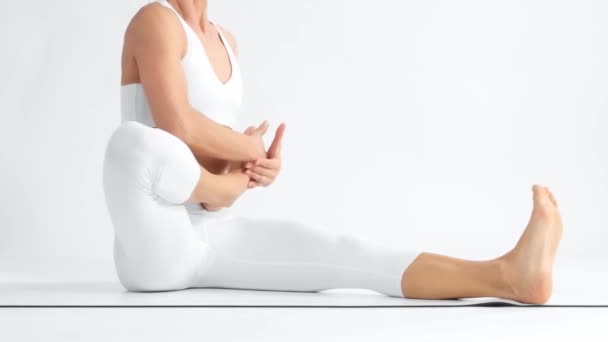 Donna anziana nello spazio bianco pratica yoga — Video Stock