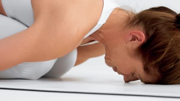Senior mulher no espaço branco prática de ioga — Vídeo de Stock