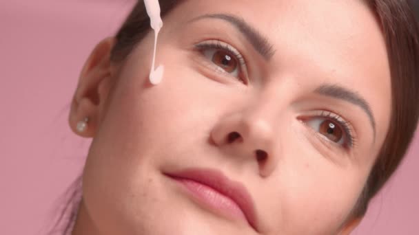 30s morena mujer lleva un top decollete con piel ideal en estudio sobre fondo rosa — Vídeos de Stock