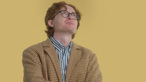 本物の男性ポートレートredhead男で眼鏡でスタジオ上の黄色カラフルな背景 — ストック動画