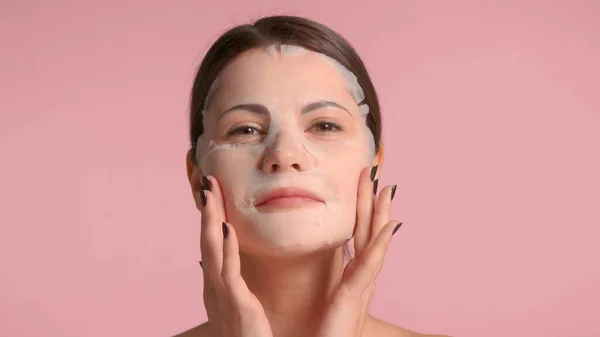 30s brunette woman closeup portrait showing a sheet mask on. Self-care concept — Stock Photo, Image