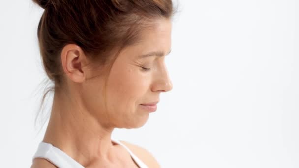 Senior vrouw in witte ruimte praktijk yoga — Stockvideo