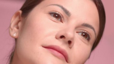 30 'lu yaşlardaki esmer kadın yağ damlatıcıyla yakın çekim yaparken yanağına yağ sürmüş.