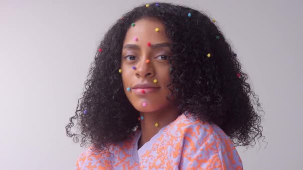 Смешанная раса черная женщина с творческим мстителем макияж простой красочной точкой макияж на безупречной коже — стоковое видео