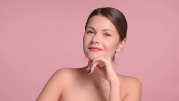 30s morena mujer lleva un top decollete con piel ideal en estudio sobre fondo rosa poses — Vídeos de Stock