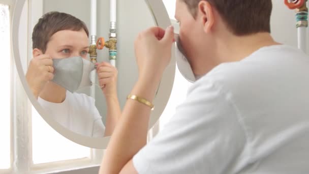 Mujer joven en el baño poner la mascarilla — Vídeo de stock