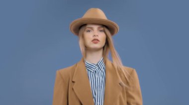 Fashion editorial portrait of blonde model with hair blowing in slow motion