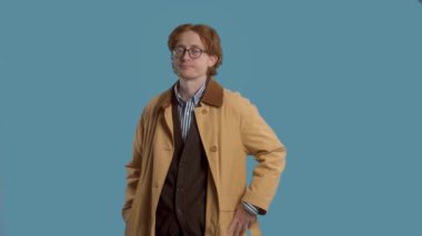 Stylish man in studio in vintage clothes turning and watching to the camera