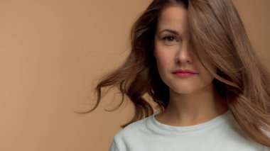 Monokrom doğal makyaj beyaz tişörtlü beyaz kadın stüdyoda esmer, dalgalı saçlı.