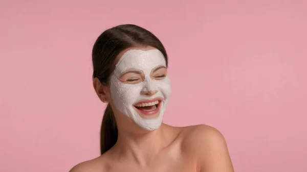 30s femme brune avec un masque d'argile faciale sur rire et s'amuser à faire des visages — Photo