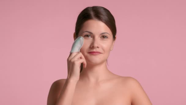 Vista frontal morena mujer de 30 años hacer un peeling facial con almohadillas de ácido pelado — Vídeo de stock
