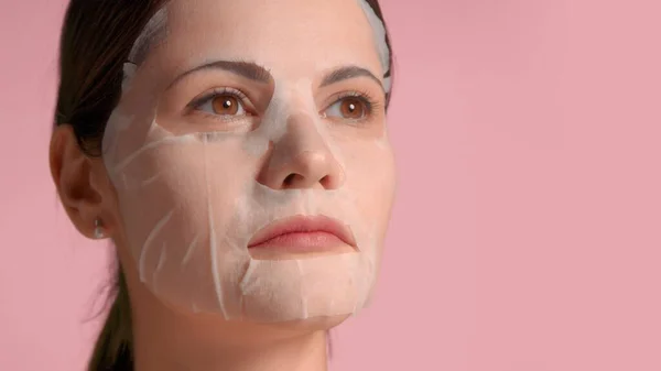 Brunette vrouw uit de 30 close-up portret met een laken masker op. Zelfzorgconcept — Stockfoto