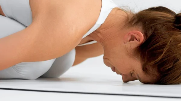 Mujer mayor en el espacio blanco practica yoga primer plano de pose relajante —  Fotos de Stock