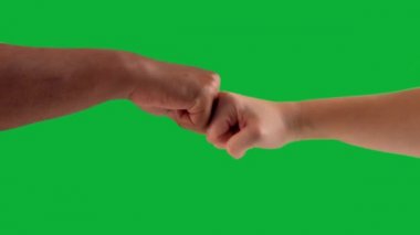 Erkek eli ile kadın eli arasında farklı ten renkleri olan bir el çakışıyor. 