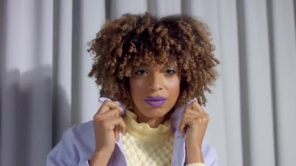 Смешанная расовая женщина на серых занавесках портрет крупным планом с красочным блестящим макияжем — стоковое видео