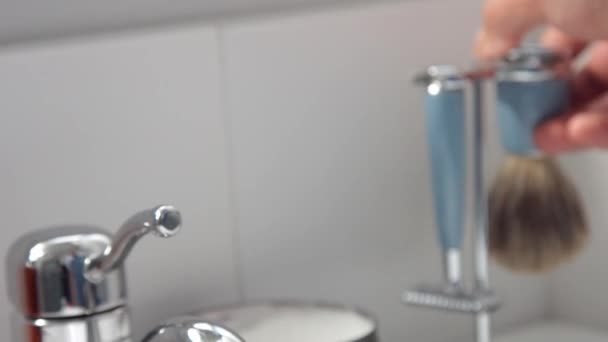 B-roll człowiek ręka wziął szczotkę do golenia i przenieść go do mokrego pod strumieniem wody — Wideo stockowe