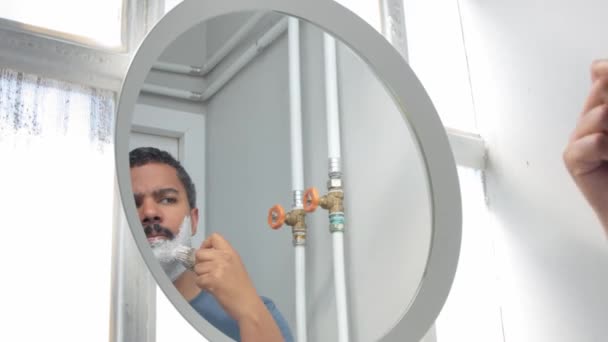 Man behind the mirror during his morning facial care routine — Stock Video