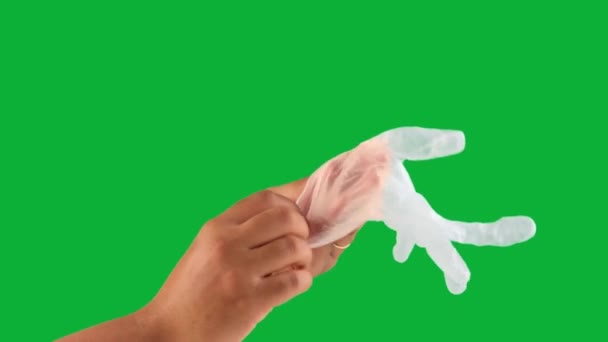 Männerhand auf grünem Chromakey zieht einen Latexhandschuh an — Stockvideo