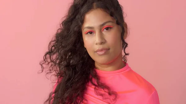 Jovem no estúdio em rosa usa uma gola alta de néon e maquiagem de néon — Fotografia de Stock