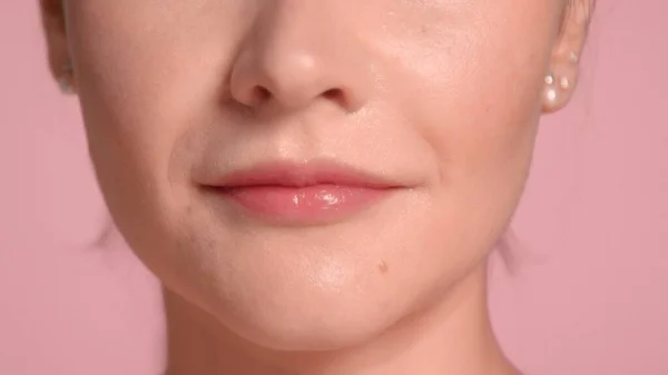 Nierozpoznawalne usta kobiet zbliżenie po zabiegu maski wargi. Koncepcja samoopieki na różowym tle — Zdjęcie stockowe