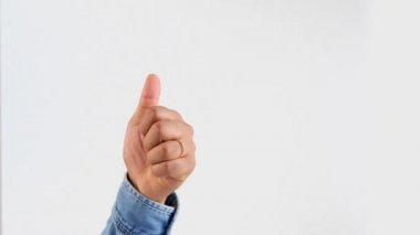 Erkek eli beyaz başparmakla işaret ediyor.