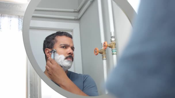 Homem atrás do espelho durante sua rotina de cuidados faciais da manhã — Vídeo de Stock