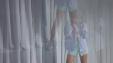 Kristalin içinden geçen karışık ırk dansçısının portresi gri perde arkasında pastel kıyafetler giyer.