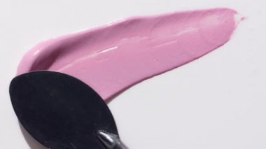 Boya spatulasıyla lekelenmiş sıvı kremalı allık damlası.