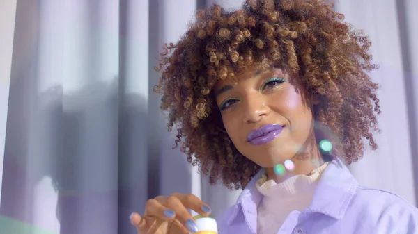 Gemengd ras zwarte vrouw met krullend haar en gloed make-up blow maken babbels — Stockfoto