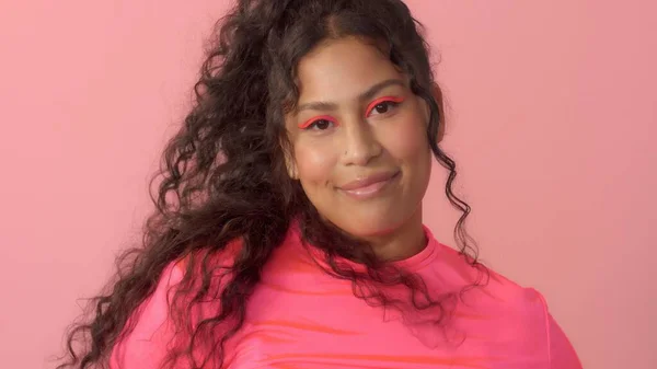 Jonge vrouw in studio op roze draagt een neon coltrui en neon make-up — Stockfoto