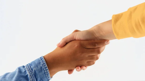 Рукопожатие между мужской и женской рукой с различными тонами кожи — стоковое фото
