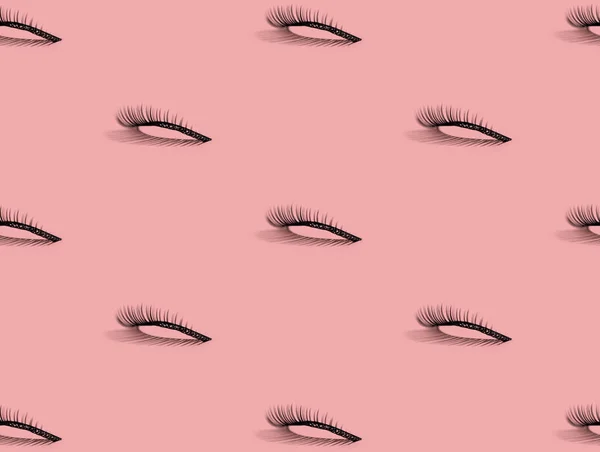 A pattern of false lashes on pink