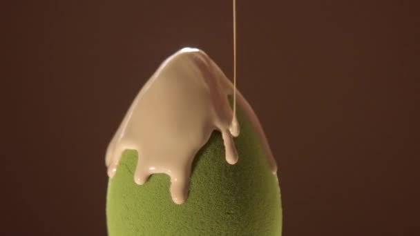 Una esponja de forma de huevo verde rodando y cara líquida y base de agua corporal vertiendo sobre ella — Vídeos de Stock