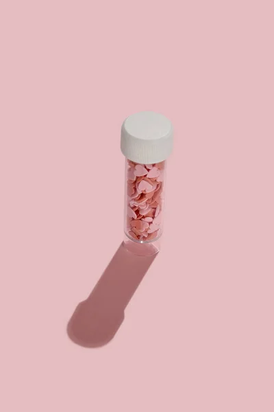 Прозрачный чехол для таблеток в форме сердца в нем на розовом фоне — стоковое фото