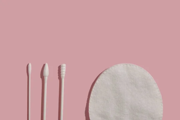 Conjunto de diferentes cotonetes em forma de algodão e uma almofada de algodão sobre fundo rosa — Fotografia de Stock