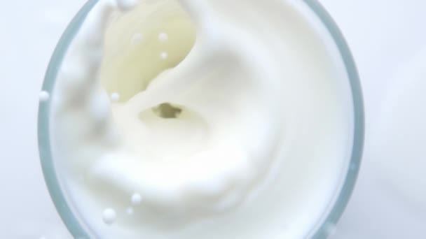 Pohled shora shora z borůvky padající do sklenice s mlékem — Stock video