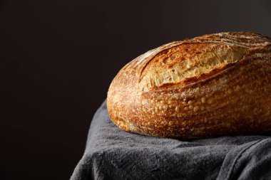 Havlunun üzerinde geleneksel köy ekmeği. Pişmiş zanaatkar ekmeği masada.