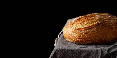 Havlunun üzerinde geleneksel köy ekmeği. Masada fırınlanmış zanaatkar ekmeği. Girdi metni için boş alanı olan panoramik çerçeve