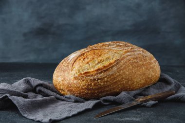 Geleneksel buğday taze rustik ekmek ve peçetede bıçak. Esnaf ekmeği. Bir somun ekmek.