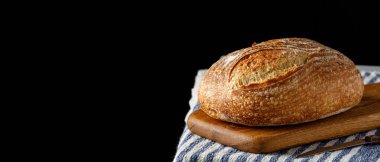 Havlunun üzerinde geleneksel köy ekmeği. Masada fırınlanmış zanaatkar ekmeği. Girdi metni için boş alanı olan panoramik çerçeve
