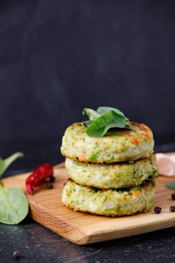 Sebze köfteleri ya da hamburgerler için pirzola, ahşap kesim masası, siyah mermer arka plan..