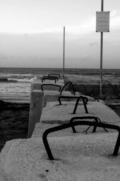 西西里一个恶劣天气的海滩和一排混凝土障碍物的生动的黑白照片 — 图库照片