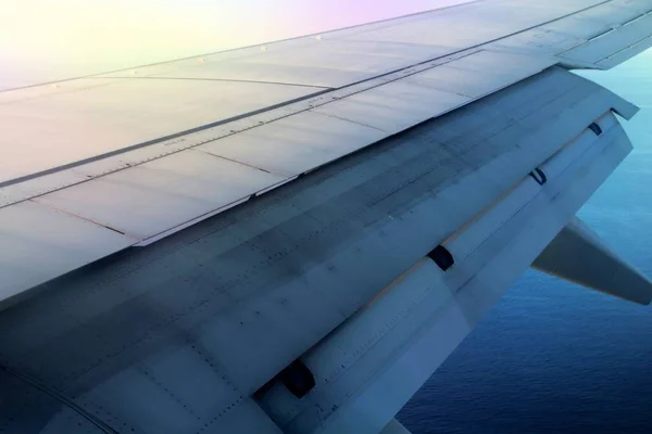 detail of the wing of an airplane with flaps moving during the flight phase just before landing