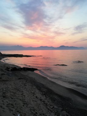 Güneş batarken ön taraftaki denizle birlikte