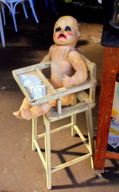 Vintage pazarında çocuklar için yüksek bir sandalyede oturan oyuncak bir bebeğin canlandırıcı görüntüsü