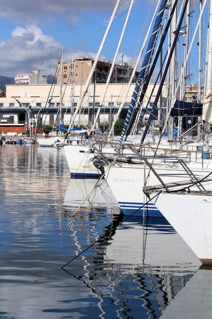 evocative image of sailboats moored in the harbor on a sunny day