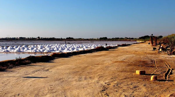 Stagnone Nature Reserve or natural reserve of the \'Saline dello Stagnone\' near Marsala and Trapani, Sicily, Italy, heaps of salt near the salt flats at sunset