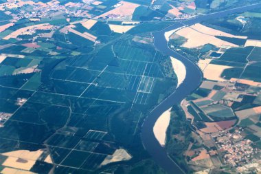 Bir uçaktan görülen nehirle İtalyan manzarasının canlandırıcı görüntüsü.